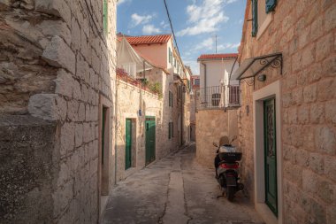 Sıcak, güneşli bir öğleden sonra Hırvatistan 'ın Split kentindeki bu tuhaf mahallede yalnız bir scooter park halinde..
