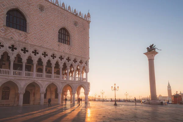 早朝の太陽光線は イタリアのヴェネツィアの聖マルコ広場のドージェ宮殿のアーチを通ってビーム — ストック写真