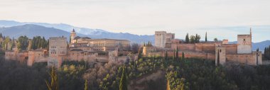 Klasik panoramik gündoğumu manzarası Charles V Palace, simgesel Alhambra ve Sierra Nevada Dağları Mirador de San Nicolas 'dan eski Granada, Endülüs, İspanya.