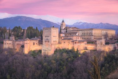 İspanya 'nın Endülüs, Granada kentindeki Mirador de San Nicolas' tan ikonik Alhambra ve Sierra Nevada Dağları 'nın canlı günbatımına sahip klasik manzara..