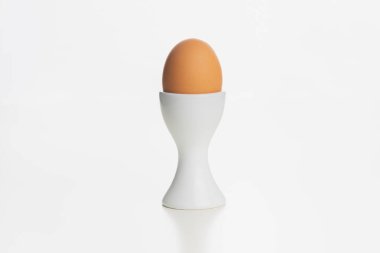 Beyaz yumurta kabındaki kahverengi bir çiftlik yumurtası. Beyaz bir yüzey ve arka planda izole edilmiş..