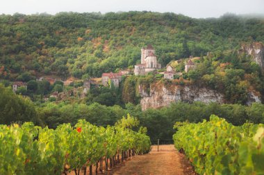 Vineyard countryside view of the French medieval hilltop village Saint-Cirq-Lapopie in the Lot Valley of southwest France. clipart