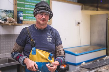 İskoçya 'nın İskoç Adaları' ndaki Skye Adası 'ndaki Oyster Shed' de taze kabuklu Atlantik istiridyesi olan bir deniz ürünleri satıcısı ya da balıkçı..