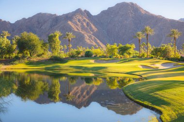 Beautiful golden light over Indian Wells Golf Resort, a desert golf course in Palm Springs, California, USA with view of the San Bernadino Mountains. clipart