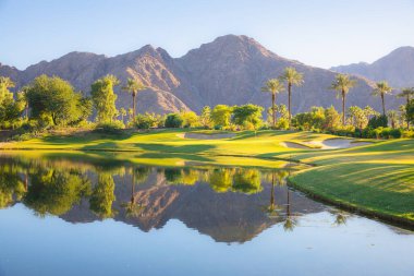 Beautiful golden light over Indian Wells Golf Resort, a desert golf course in Palm Springs, California, USA with view of the San Bernadino Mountains. clipart
