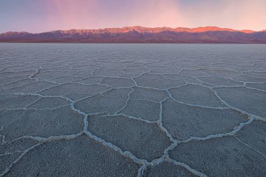 Güzel, ilham verici manzara ve Badwater Havzası tuz düzlüklerinin halkalı dokusu altın bir günbatımında veya Birleşik Devletler 'deki Ölüm Vadisi Ulusal Parkı' nda gün doğumunda.