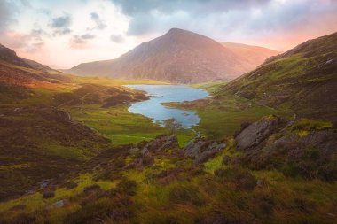Kuzey Galler 'deki Snowdonia Ulusal Parkı' nın Gyderau dağlarındaki Cwm Idwal 'ın dramatik manzarası gün batımında ya da gün doğumunda.