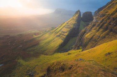 Golden ethereal sunrise or sunset light over beautiful, idyllic mountain landscape of Dun Dubh at the Quiraing on the Isle of Skye, Scottish Highlands, Scotland. clipart