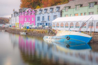 Sonbaharda İngiltere 'nin Skye Adası, İskoçya' nın renkli kıyı köyü Portree 'de yüksek gelgitte limanda bir balıkçı teknesi battı..