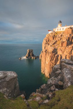 İskoçya 'nın Skye Adası' ndaki Neist Point Deniz Feneri 'nin sahil kıyısı yarımadasında dramatik altın gün batımı ya da gün doğumu.