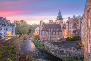 İskoçya, Edinburgh 'da Leith' in suyu boyunca Dean Village 'ın tarihi mimarisinin üzerinde canlı, renkli gün batımı ya da gün doğumu gökyüzü.