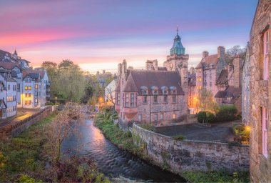 Vibrant, colourful sunset or sunrise sky over the historic architecture of Dean Village along the Water of Leith in Edinburgh, Scotland. clipart