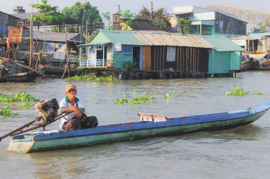 Vietnam 'ın başkenti Can Tho' daki Mekong Deltası 'nda Hau (Bassac) nehri boyunca geleneksel bir teknede genç bir Vietnamlı..