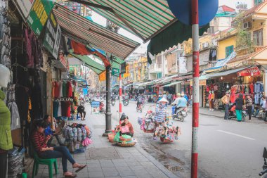 Vietnam 'ın orta kesimindeki Hanoi şehir merkezinin hareketli, renkli caddeleri ve dükkan cepheleri boyunca yerel Vietnamlılar ve şehir yaşamı.