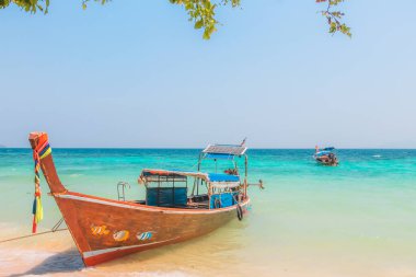 Tayland 'daki Koh Phi Phi' de, Loh Moo Dee Sahili 'nin kumlu tropikal sahilinde renkli bir geleneksel Tayland balıkçı teknesi..