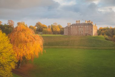 Dalkeith Country Park, Edinburgh, İskoçya 'daki tarihi Dalkeith Sarayı' nın üzerinde altın saat gün batımı parlıyor..