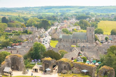 Corfe Castle, İngiltere - 24 Haziran 2021: Bir yaz günü İngiltere 'nin Dorset kentindeki Corfe Kalesi' nin tarihi ortaçağ köyünün havadan görünüşü.