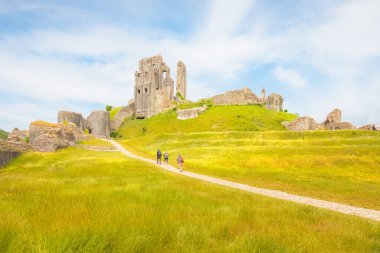 Corfe Castle, İngiltere - 24 Haziran 2021: Turistler güneşli bir yaz gününde İngiltere 'nin Dorset kentindeki Corfe Şatosu' nun ortaçağ kalesi kalıntılarını ziyaret ettiler.