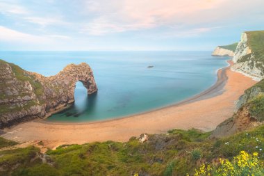 Günbatımında ya da İngiltere 'nin Dorset kentindeki Jurassic Sahili' nde gün doğumunda ikonik deniz manzarası kaya oluşumu deniz kemeri Durdle Door..