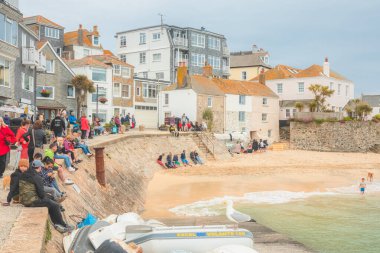 St Ives, İngiltere - 21 Haziran 2021: Cornish liman kenti St. Ives, Cornwall, İngiltere 'nin manzaralı limanının tadını çıkaran turistler.