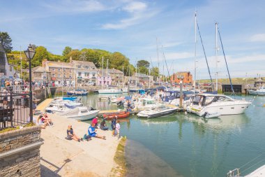 Padstow, İngiltere - 18 Haziran 2021: Turistler İngiltere 'nin Cornwall kentindeki Cornish liman kasabasındaki Padstow Limanı' nda güneşli bir yaz gününün tadını çıkarıyorlar.