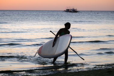 Bir kız deniz Plajı'nda sup surfboard ile silüeti 