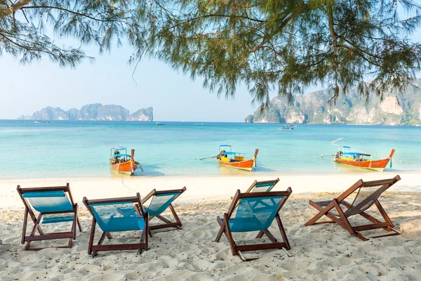 Bamboo beach chairs and traditional long-tail boats — Stock Photo, Image