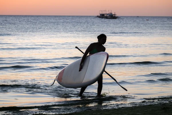 Silhueta de uma menina com a prancha de surf sup na praia do mar — Fotografia de Stock