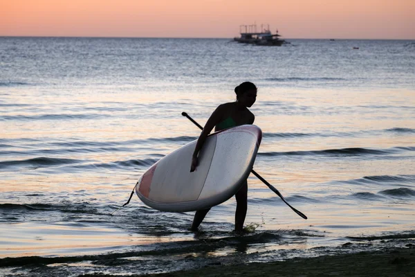 Silhouette di una ragazza con la sup surf sulla spiaggia del mare — Foto Stock