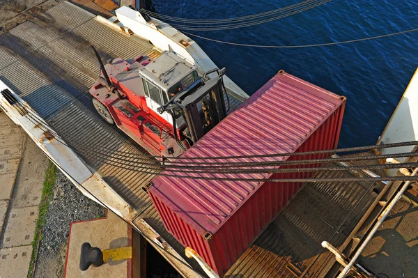 Погрузчик с контейнером, заходящим на судно — стоковое фото