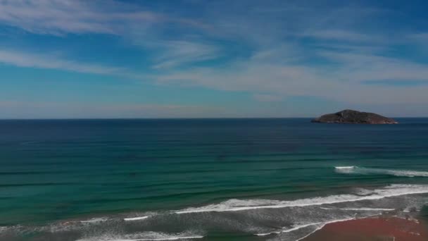 海洋景观与小岩石岛屿和起伏的海浪 摄象机把蓝色海水的多个阴影投射到岛上 以引起人们的注意 — 图库视频影像