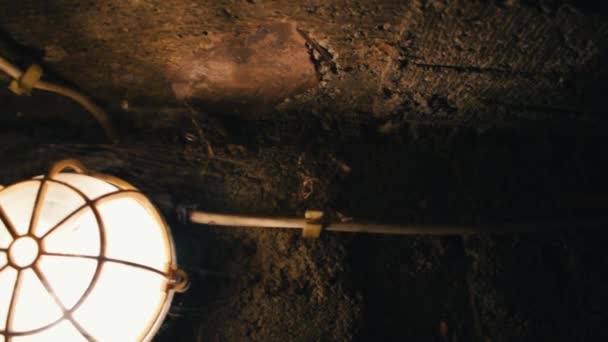Dolly záběr lampy v jeskyni nebo suterénu.