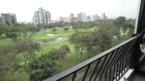 多莉拍摄了从附近一座大楼的阳台上看到的高尔夫球场美景 在地平线上可以看到附近居民区的几栋建筑物 — 图库视频影像