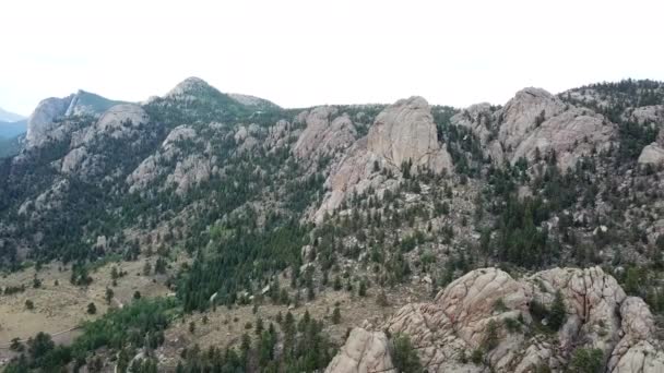 Aerial Shot Descending Face Rocky Mountain Ridge Green Trees White — Stock Video