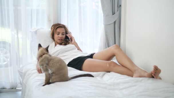 Ασιάτισσα Γυναίκα Κάνει Ένα Τηλεφώνημα Στο Κρεβάτι Γάτα Στο Σπίτι — Αρχείο Βίντεο