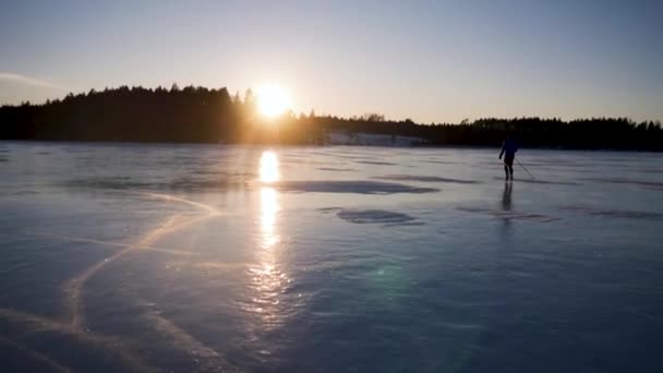 スウェーデンのサンセットにある凍った湖でスケート — ストック動画