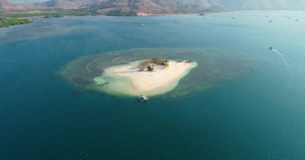 在印度尼西亚的一个阳光明媚的日子里 无人驾驶飞机在伦博克海岸的一个小岛上 向一艘游船和一名男子射击 — 图库视频影像