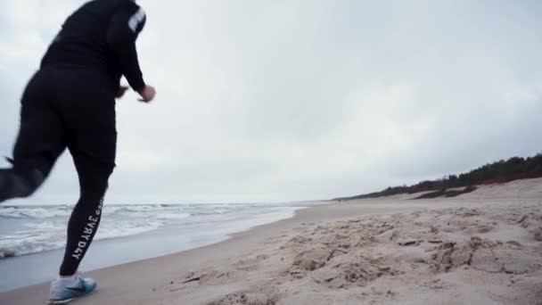 Corredor Con Ropa Deportiva Negro Está Corriendo Playa Lejos Cámara — Vídeos de Stock