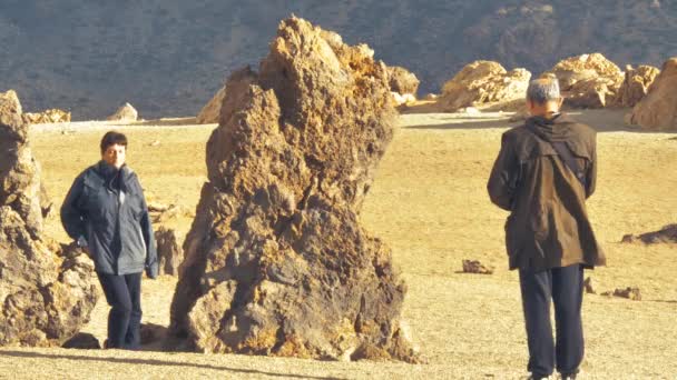 一位摄影师与一位妇女在提德国家公园的一些大型岩石群附近合影 加那利群岛旅游胜地这一地区干燥的褐色岩石地形 — 图库视频影像