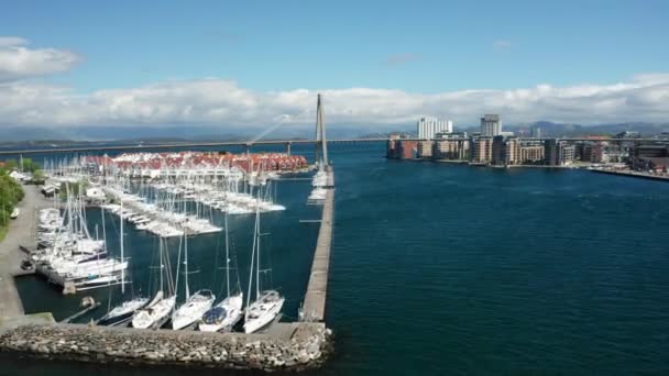 ノルウェーの石油産業の首都で湾を渡る典型的な北欧の家とBybrua橋を持つスタバンガーセーリングボートマリーナシネマティック航空4K — ストック動画