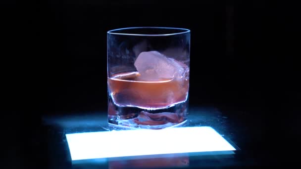 老式玻璃杯 从底部在黑色孤立的背景前发光 — 图库视频影像