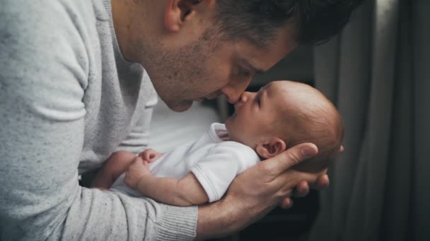 父亲抱着新生婴儿 脸蛋紧闭 鼻子摸着 爸爸和小宝宝之间的柔情时刻父母和孩子的慢动作观点 — 图库视频影像