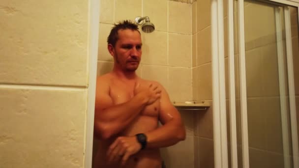 シャワーを浴びて髪と顔と体を洗っている男のロックされたショット — ストック動画