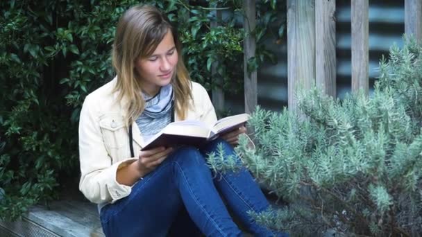 Menina Adolescente Atraente Livro Pátio Entre Plantas — Vídeo de Stock