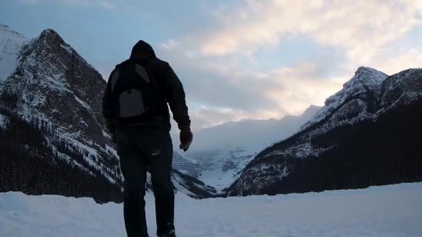 Człowiek Spacerujący Zamarzniętym Jeziorze Górami Tle — Wideo stockowe