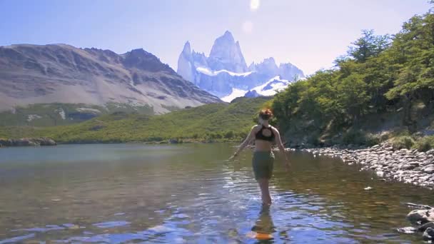 ラグナ カルピの湖を歩いている若い女性は アルゼンチンのパタゴニアにあるフィッツ ロイを見ている アルゼンチンのエルチャルテン近くでフィッツ ロイをトレッキング 旅と冒険のコンセプト — ストック動画
