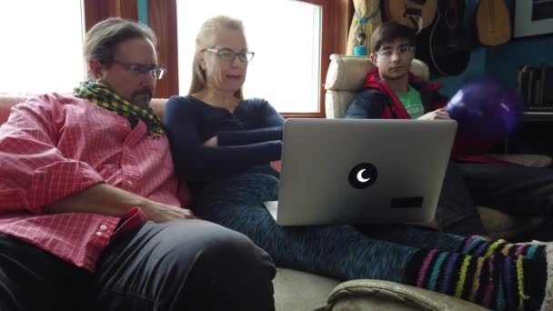 A család eléjük néz és beszél valamiről a számítógép képernyőjén..