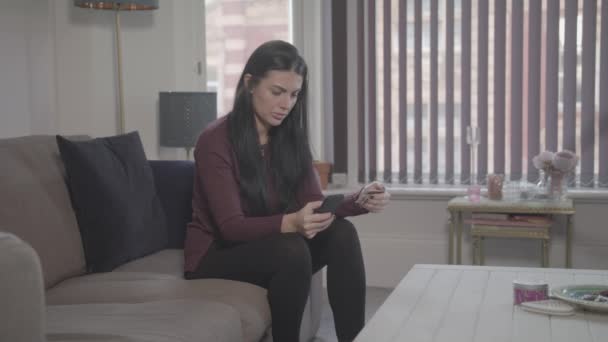 Jonge Aantrekkelijke Vrouw Zit Thuis Maakt Gebruik Van Smart Phone — Stockvideo