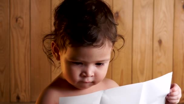 Young Toddler Reading Smiling Camera Looking Wooden Background Yellow Rim — Stock Video