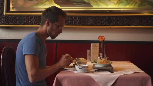 Seitenwinkelaufnahme Eines Mannes Der Asiatisches Essen Isst Und Einem Asiatischen — Stockvideo